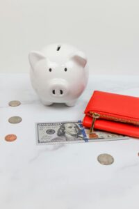 Red women's wallet with a US dollar bill partially underneath, symbolizing blog income or personal finance in 2025
