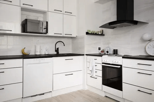 White kitchen cabinets with matte black hardware, faucet, and range hood