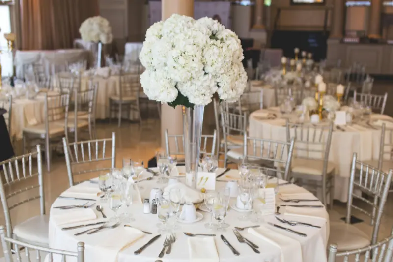minimalist white table setup with white hydrangea centerpiece and white plates for home gathering