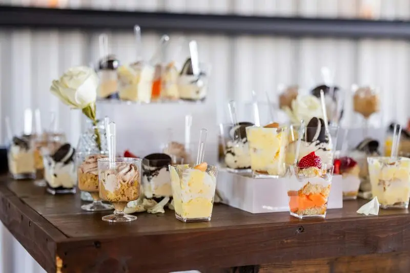 mini dessert cups display at different heights on wooden table for home gathering ideas