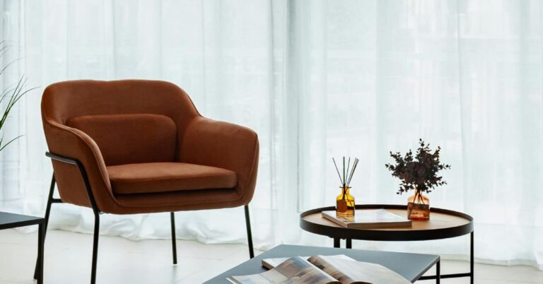 Small apartment living room setup with a cozy velvet accent chair and minimalist decor for summer.