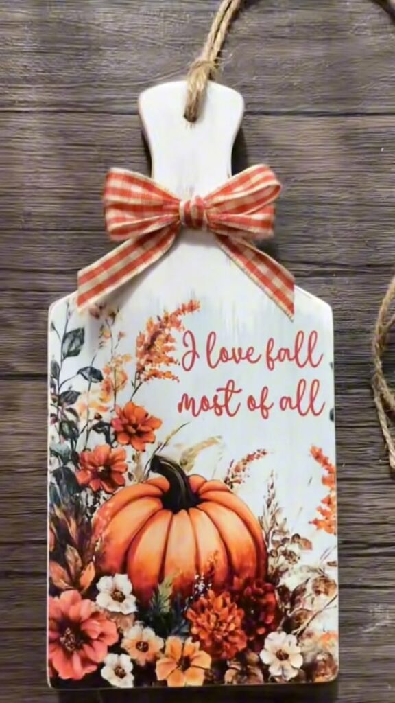 wood-burned cutting board with pumpkin and floral design surrounded by pumpkins
