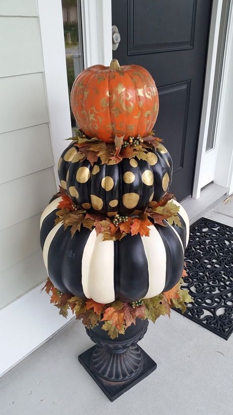 Stacked painted pumpkins in gold damask, polka dot, and striped patterns by a front door