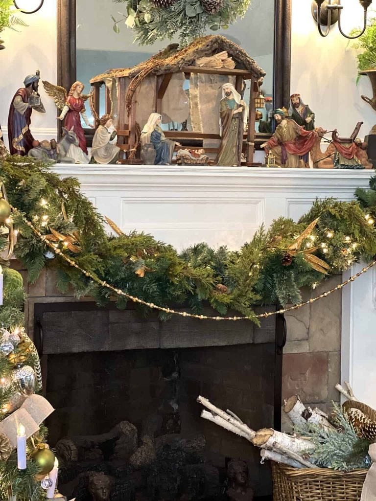Christmas mantel styled with a full nativity figurine set and pine garland