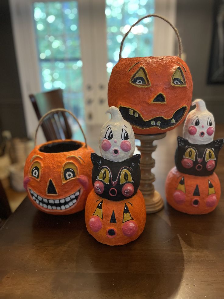 Cluster of paper mache pumpkin buckets and stacked ghost-and-cat figures, vintage Halloween decor style