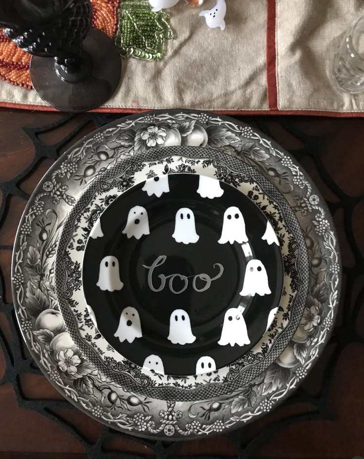 Vintage-style ghost plates layered on black and white china for a Halloween table setting