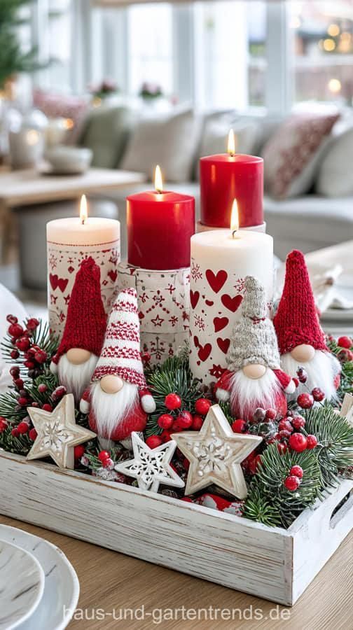 Knit hat gnomes with red and white striped pillar candles and wood star decor on a winter centerpiece tray