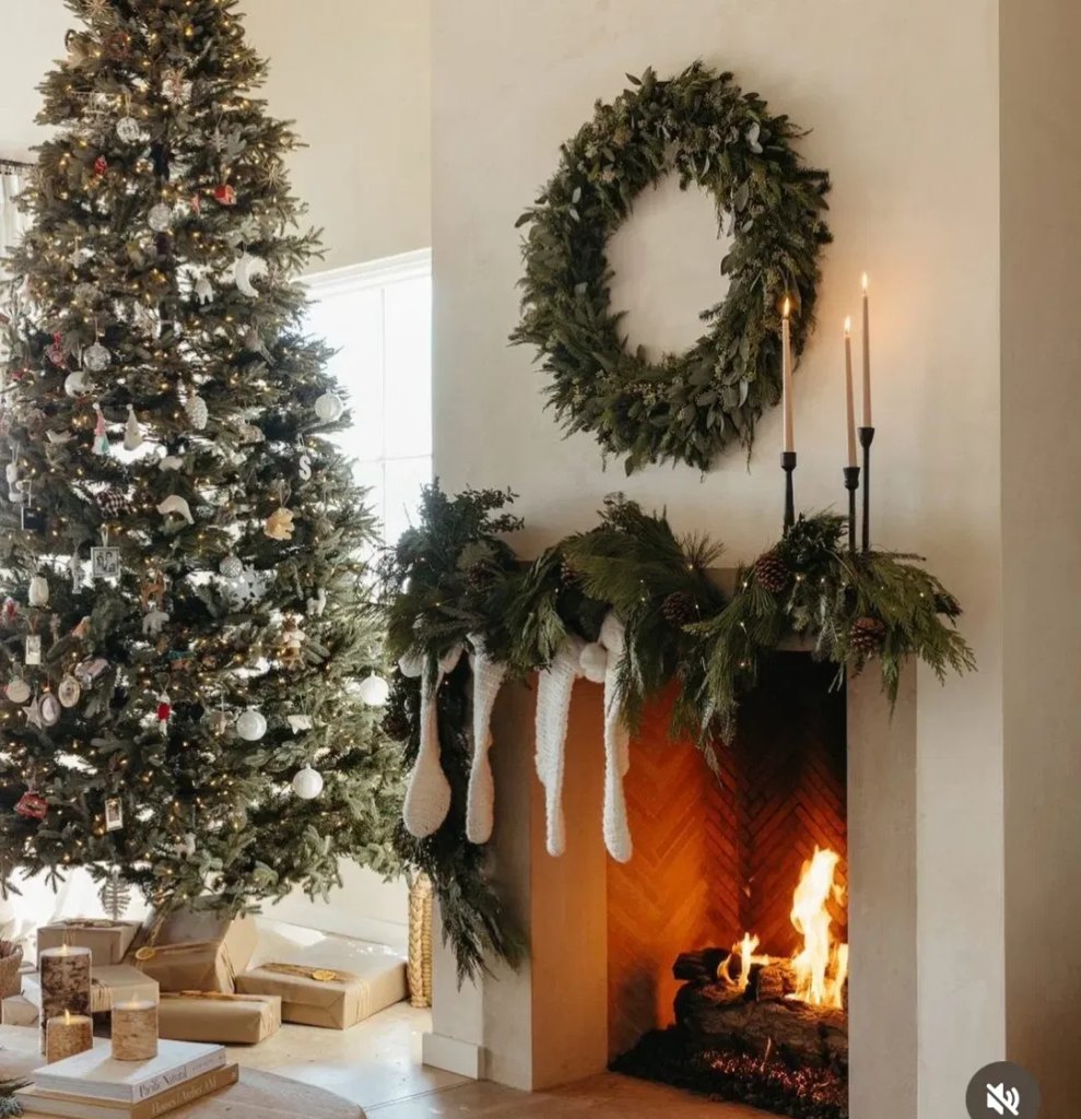 Christmas mantel with garland, stockings and candles in a living room