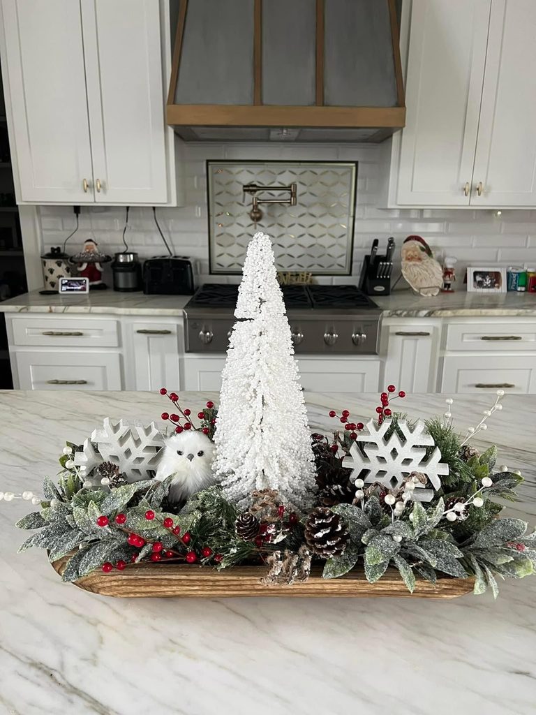 Long wood dough bowl with a white tree, snowflakes, frosted greenery and an owl on a marble counter