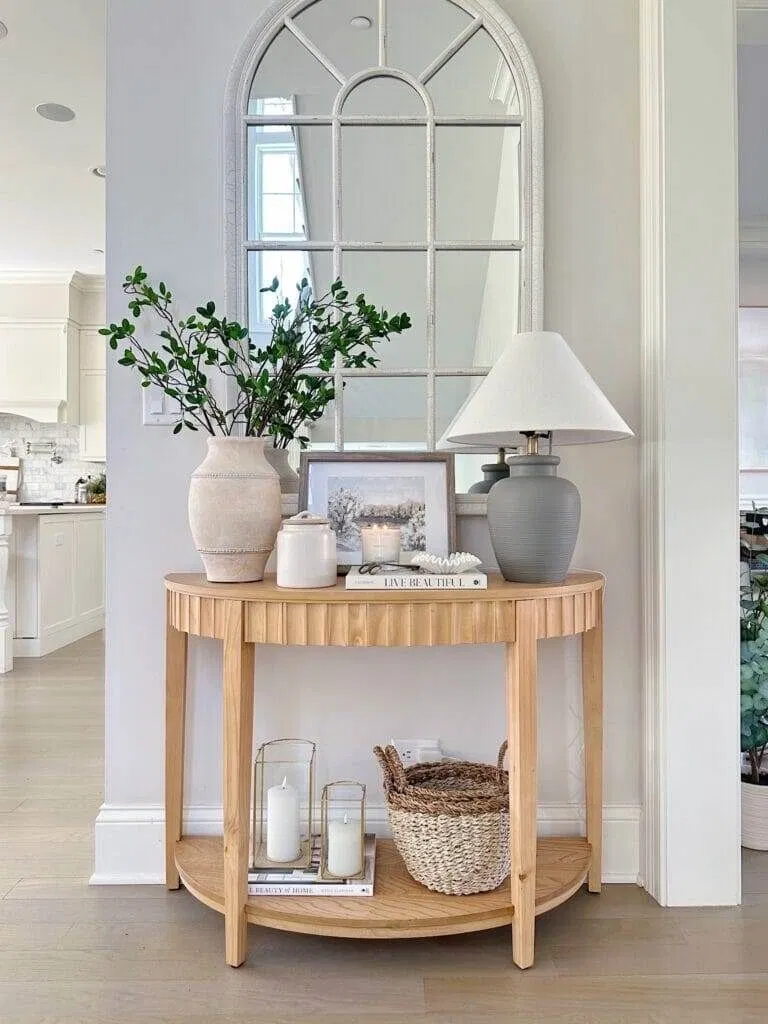 half-moon wood console table with a window-pane mirror above it, small entryway table decor