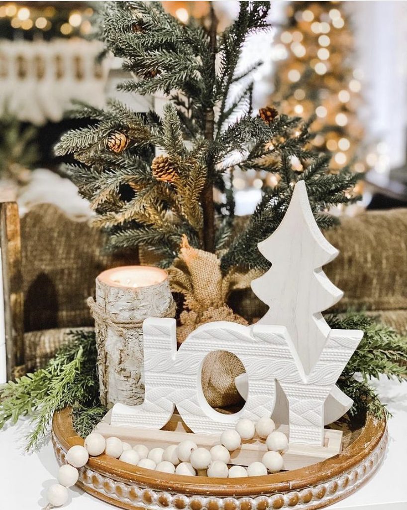 Rustic wood tray with a birch bark candle, a JOY sign, a burlap-wrapped pine tree and wood beads